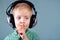 Little boy listening music on headphones. sign quieter