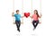 Little boy and a little girl on a swing holding a red heart and looking at the camera