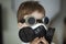 Little boy look toward in black respirator and black glasses blurred background