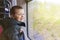 Little boy looking through the bus window. Travelling with children