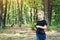 Little boy looking far away in forest during family journey.