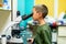 The little boy looks through a microscope in a laboratory with curiosity.  Children came on an excursion to the clinic