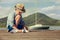 Little boy make paper boats sitting on the wooden pier