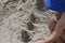 A little boy makes sand cakes on the beach