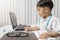 little boy in medic uniform holding a pen on desk