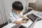 Little boy in medic uniform using a cellphone on desk