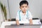 Little boy in medic uniform using a laptop on desk, Careers in children`s dreams concept