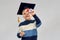 Little boy in mortarboard looking through diploma