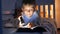 Little boy in pajamas lying in bed and reading bedtime story book with torch. Children education, development, secrecy, privacy,