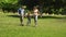 Little boy and parents running towards camera in the park holding hands