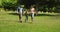 Little boy and parents running towards camera in the park holding hands