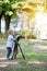 Little boy photographing on the camera on tripod in the park