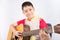 Little boy playing classic guitar course on white background