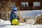 A little boy is playing with a dog on the snow outside