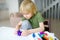 Little boy playing dough at home during coronavirus quarantine. Child is molding from plasticine model virus covid-19.