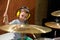 Little boy playing drums with protection headphones