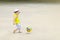 A little boy is playing football, the ball is flying. Active child in summer with a ball