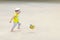 A little boy is playing football, the ball is flying. Active child in summer with a ball