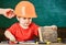 Little boy playing with hammer. Daddy adjusting sons protective helmet. Small kid helping his workshop