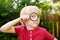 Little boy playing with magnifying glass. Little boy carefully looking at you with magnifier