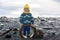 Little boy, playing with rocks on the beach in beautiful nature in Snaefellsjokull National Park in Iceland