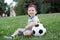 Little boy plays football on the football field gives a pass hits the ball runs across the field and scores a goal