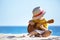 Little boy plays guitar ukulele at sea beach