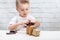 Little boy plays with the robot. Child collects a robot sitting at the table