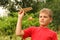 Little boy plays with wooden airplane on nature