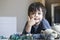 Little boy pointing finger on his nose and laying on the floor playing with soldiers and figurine toys in kid playroom, Active Kid