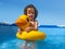 Little boy in the pool stand with inflatable duck playing