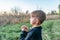 Little boy prays on a quiet evening in nature. Spiritual unity of man with nature