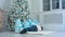 Little boy pretending to sleep on the carpet next to the Christmas tree