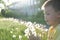 Little boy profile blowing dandelion flower at summer. Happy smiling child enjoying nature in park