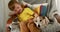 Little boy pulls faces and pets dog with brown and white fur