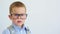 little boy pupil in glasses, backpack blue shirt making funny face grimaces