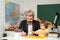 Little boy pupil with happy face expression near desk with school supplies. Individual teaching. Pupil of primary school