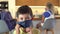 Little boy puts on a protective mask at home looking at camera, at home