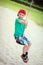 Little boy in red cap sit on swing rope