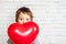 Little boy with red heart shaped baloon, Valentine's day background