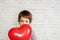 Little boy with red heart shaped baloon, Valentine's day background