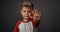 Little boy in red shirt unhappy showing stop with his hand isolated on grey background. Human emotions, facial