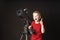 A little boy in a red T-shirt tells interesting facts about a telescope and holds his thumb up.