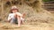 Little boy relaxing near the stack of hay