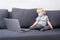 A little boy in a respiratory mask stays home in quarantine and watches cartoons on a laptop