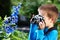 Little boy with retro camera shooting macro flowers