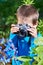 Little boy with retro SLR camera shooting macro flowers