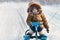 Little boy riding his kids snowmobile winter snow-covered road