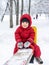 Little boy riding on swing in winter