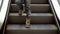 Little boy rises on the escalator. The boy goes down on escalator steps in shopping center. Christmas shopping. Slow